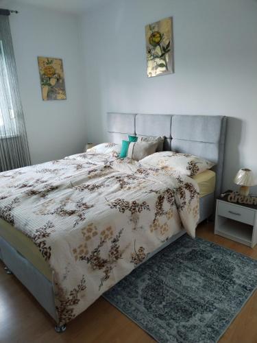 a bedroom with a bed with a comforter and a rug at Yellow Rose in Rakovica