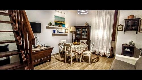 a dining room with a table and chairs and a desk at Antica Dimora DE FERRERA - Alghero in Alghero