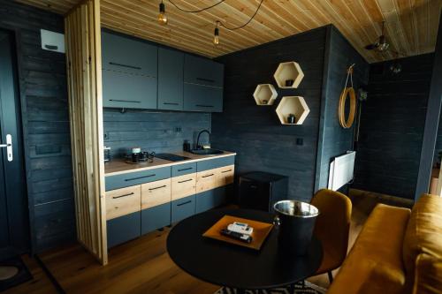 a kitchen with blue cabinets and a table in a room at The Altitude Cabin Resort in Măguri