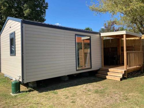 a tiny house with a porch and a deck at Camping 3 étoiles - Piscine - ccaihff in Saint-Georges-de-Didonne