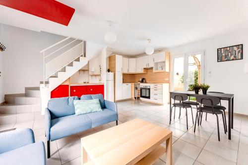 a living room with a blue couch and a table at Le Mûrier - Maison de ville avec patio parking - 6 pers in Lyon
