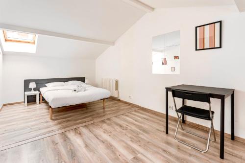 une chambre avec un lit et un bureau dans l'établissement Le Mûrier - Maison de ville avec patio parking - 6 pers, à Lyon