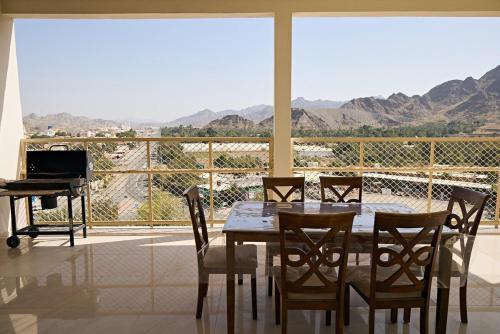 a dining room with a table and chairs and a piano at Mountain Majesty 4 Bed Home - BBQ Retreat in Masāfī