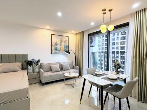 a living room with a bed and a table and a couch at HN ETH Vinhomes D'capitale Resident - Tran Duy Hung St in Hanoi