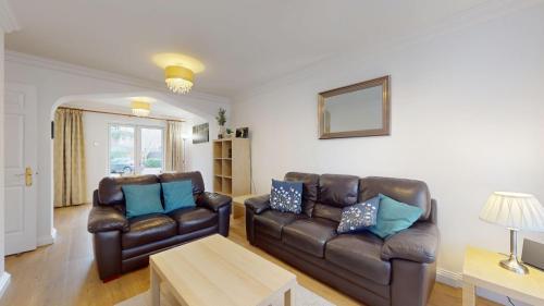 a living room with two leather chairs and a table at Rewley Road in Oxford