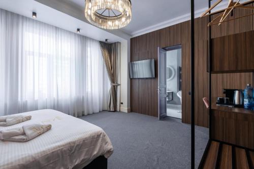 a hotel room with a bed and a chandelier at HIGHLINE DOWNTOWN ApartHotel OLDTOWN UNIRII SQUARE in Bucharest