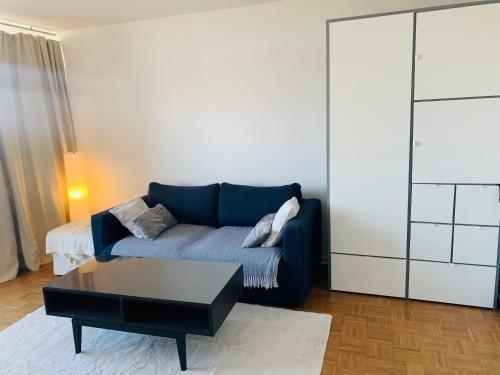 a living room with a blue couch and a coffee table at Business Messe Apartment & Wellness Spa in Düsseldorf