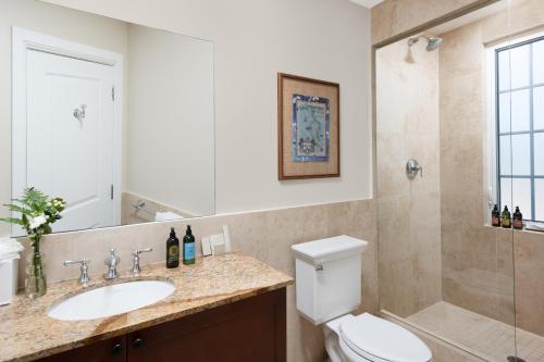 a bathroom with a toilet and a sink and a shower at One Grace Bay Townhomes 205 - 2 BR in The Bight Settlements