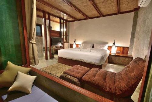 a bedroom with a bed and a couch in a room at Sai Daeng Resort in Koh Tao
