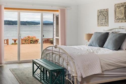 a bedroom with a bed and a view of the water at Spacious Beach Front Home on Hood Canal in Belfair