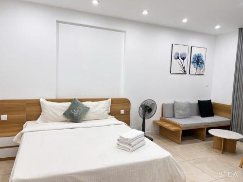 a bedroom with a large white bed and a chair at HN ETH Vinhomes D'capitale Resident - Tran Duy Hung St in Hanoi