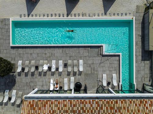 a large swimming pool with chairs and a swimming pool at Hôtel Atalante - Relais Thalasso & Spa in Sainte-Marie-de-Ré