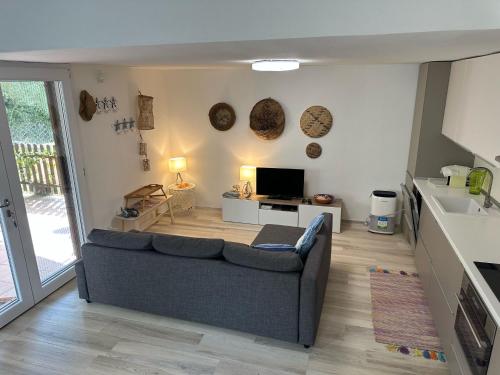 a living room with a couch and a tv at La casa di Sara in Capo Sperone