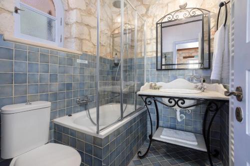 a bathroom with a tub and a sink and a toilet at Villa Nephos in Koiliomenos