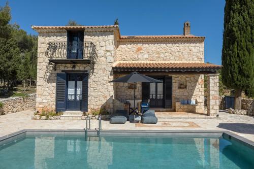 a villa with a swimming pool in front of a house at Villa Nephos in Koiliomenos