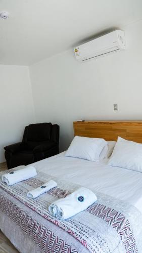 a bedroom with a bed with two towels on it at Hospedaje La Angostura in Ica