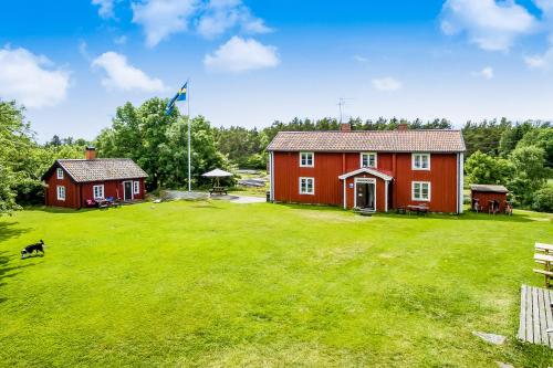 a red house with a dog in a yard at Bull-August gård vandrarhem/hostel in Arholma