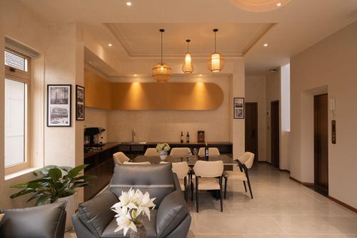 a dining room and living room with a table and chairs at New Memories Hotel DaLat in Xuan An