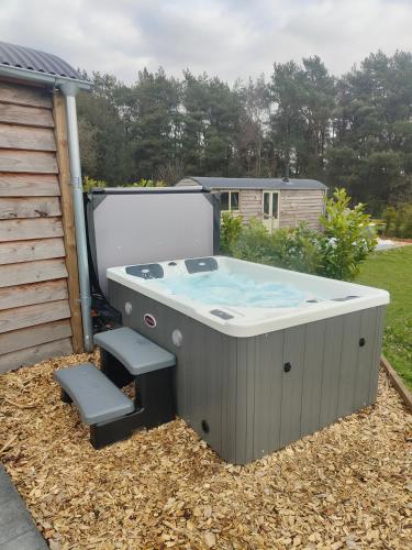 a hot tub in a yard next to a shed at Middlehead Huts in Newton