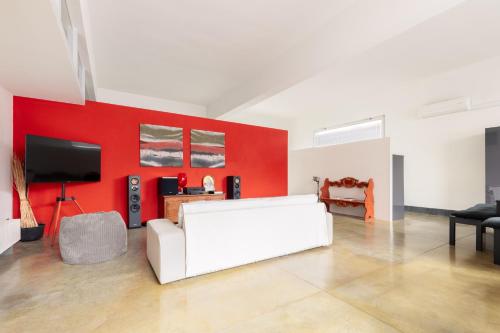 a living room with a white couch and a red wall at Tuscany Crossroad in Empoli