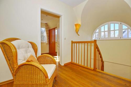 einen Flur mit Korbstühlen und eine Treppe mit Fenster in der Unterkunft Ferienhaus Nanni in Wittenbeck