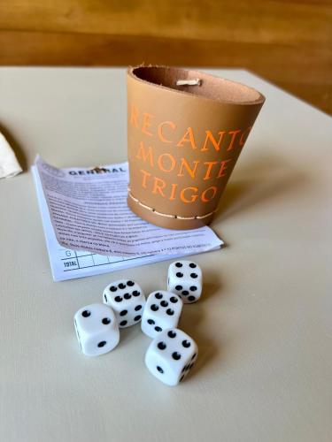 a pile of dice next to a cup of coffee at Chalé Barril com cozinha in São Francisco do Sul