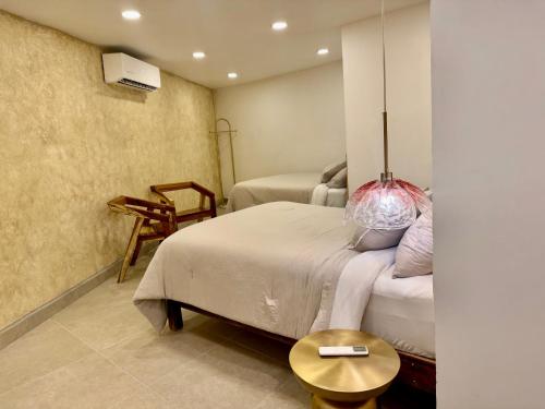 a bedroom with two beds and a table at Casa Palma in Xochitepec