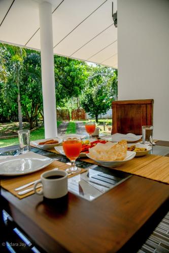 a wooden table with food and drinks on it at Eco Friendly Lodge in Udawalawe