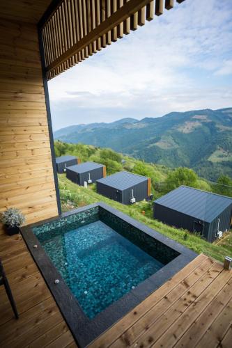 a pool in a house with a view of the mountains at The Altitude Cabin Resort in Măguri