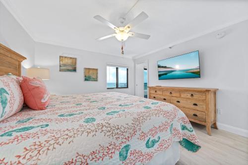 a bedroom with a bed and a ceiling fan at Corner oceanfront views with wrap around balcony located on the no-drive beach! in New Smyrna Beach