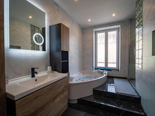 a bathroom with a large tub and a sink at Méga Jeanne d'Arc Billard Baby Foot en option Escape Game Logements Insolites in Nancy