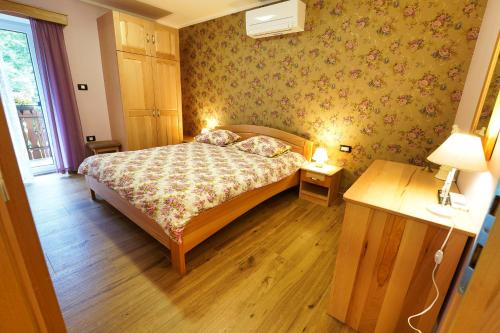 a small bedroom with a bed and a wooden floor at Domačija Bubec in Ilirska Bistrica