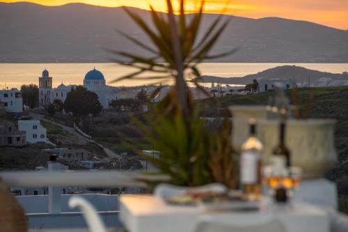 a view of a city from a table with a sunset at Touch Naxos Sunset in Galanado