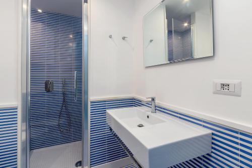 a bathroom with a white sink and a shower at Mansarda del Corso in Sorrento