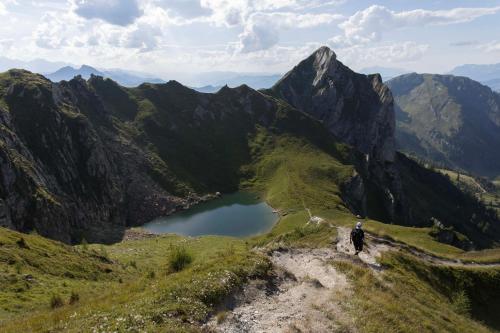 a man standing on the edge of a mountain overlooking a lake at Appartements KATHRIN in Grossarl