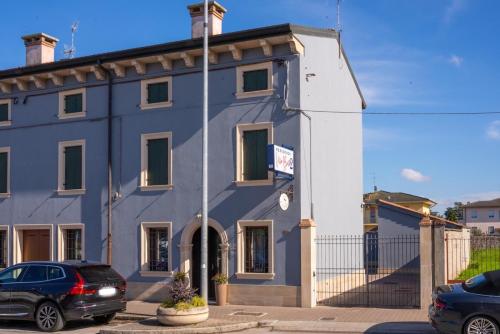 a blue building with a car parked in front of it at Residenza Villa Bella 2 in Mozzecane