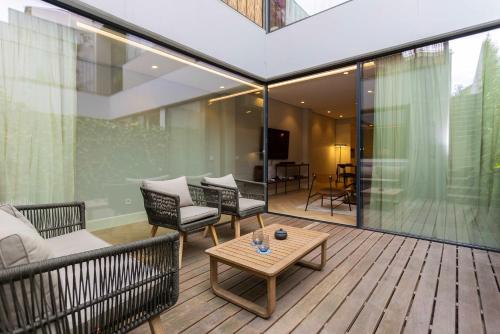 a balcony with chairs and a table on a building at Liiiving in Porto - Pool Paradise Apartments in Porto
