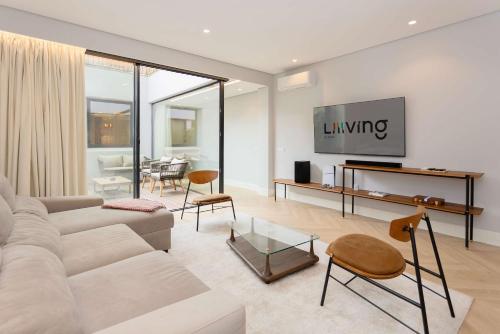 a living room with a couch and a tv at Liiiving in Porto - Pool Paradise Apartments in Porto