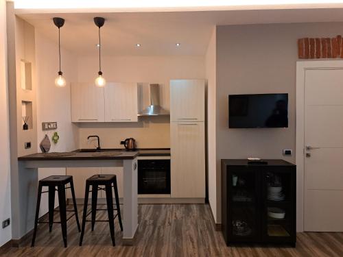 a kitchen with a counter and two bar stools at Cascina Colombo in Oleggio