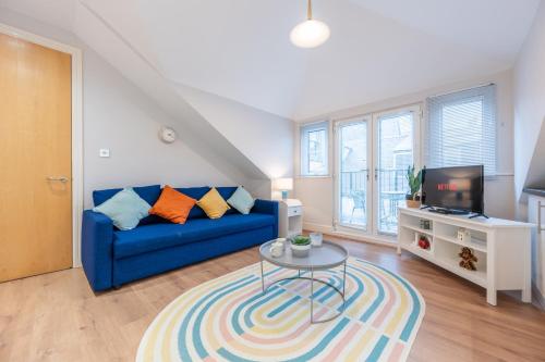 a living room with a blue couch and a table at 2 Bed Apartment - Cardiff City Centre - Free Parking in Cardiff