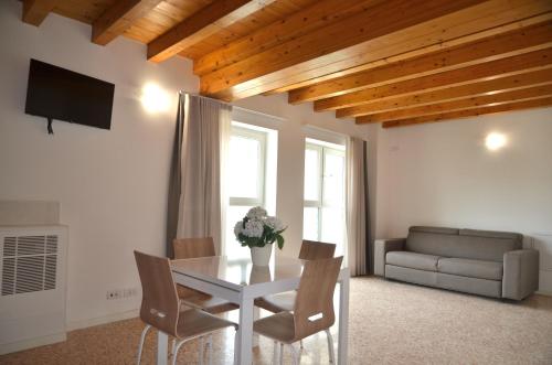 a living room with a table and chairs and a couch at Palazzo Maggiore Suite B in Noale