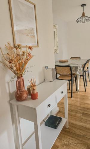 a white table with a vase on top of it at Welcome Home in Royston