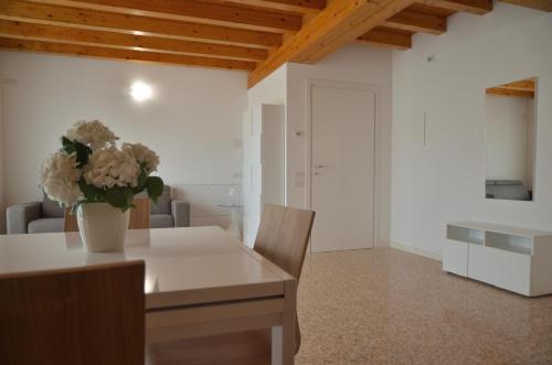 a dining room with a table with a vase of flowers on it at Palazzo Maggiore Suite B in Noale