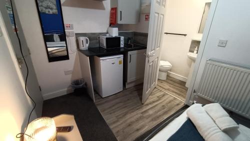 a small kitchen with a sink and a microwave at Comforatable Modern Studios in Nottingham