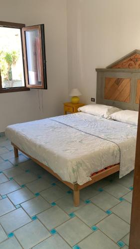 a bed in a bedroom with a tiled floor at Vista mare montagna da Marcello in Cala Gonone