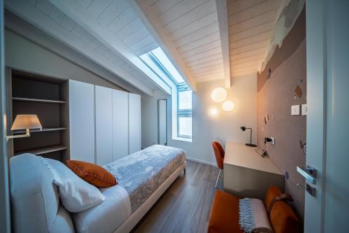 a bedroom with a bed and a desk and a window at Trilocale Atlantico Treviglio Upper Stay in Treviglio