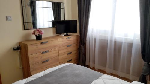 a bedroom with a dresser with a television on top of it at Victoria Family Hotel in Balchik
