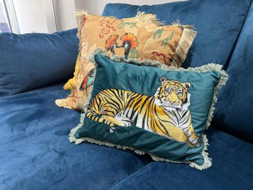 a pillow with a tiger on it sitting on a couch at Luxurious Modern House With Garden Close To City Centre in Cardiff
