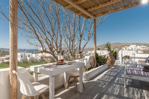 a white table and chairs on a patio with a view at Touch Naxos Sunset in Galanado
