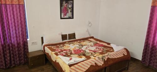 a bedroom with a bed with a floral blanket on it at Fortune Retreats in Ooty